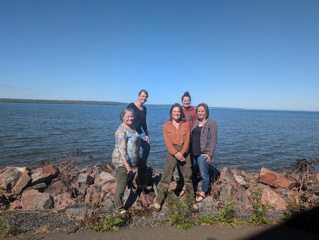 Members of the FoodWIse Team standing in front of Lake Superior dressed for early fall.