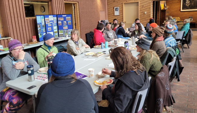 people gathered, eating around a table.